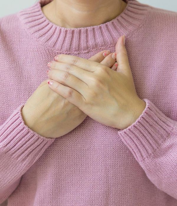 Woman in a peaceful yoga pose in a room with soft, warm light.